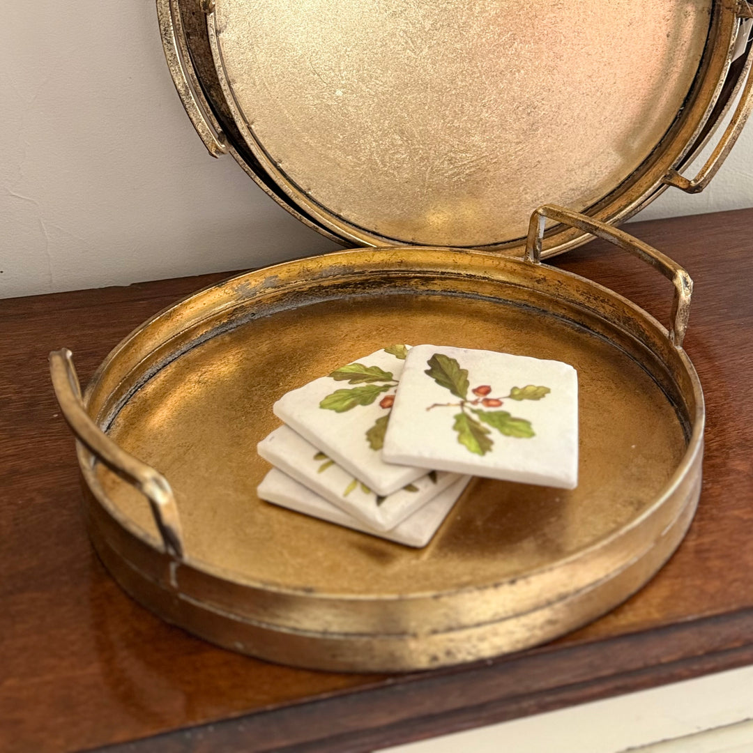 Stack of decorative coasters on a gold tray.