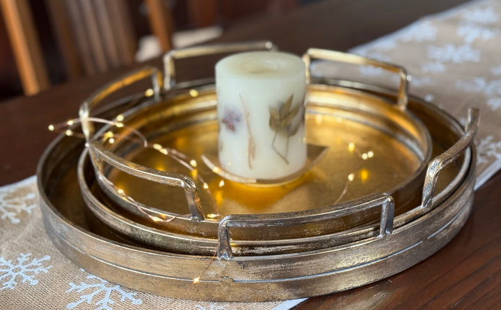 Decorative metal tray with a candle on a table
