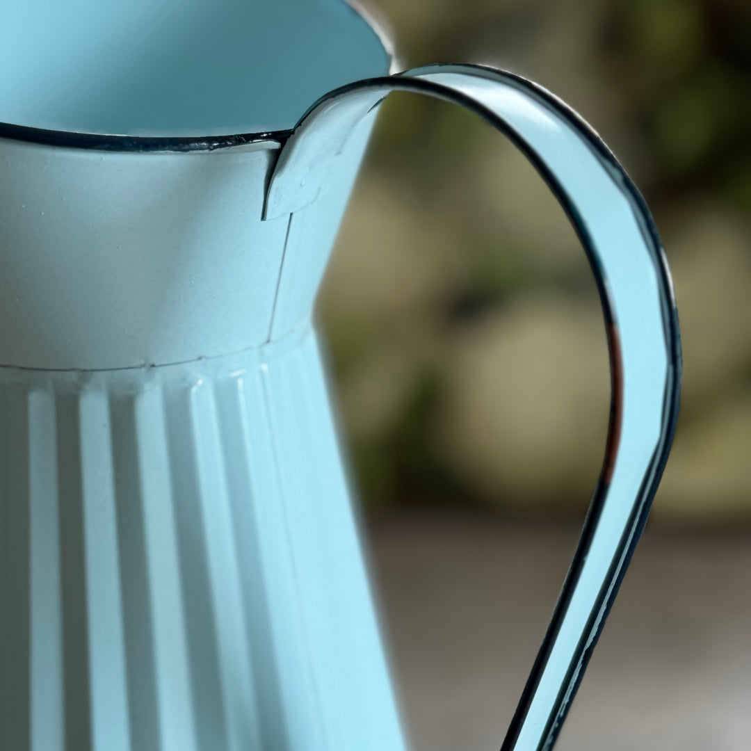 Close-up of a pale blue pitcher with a blurred background