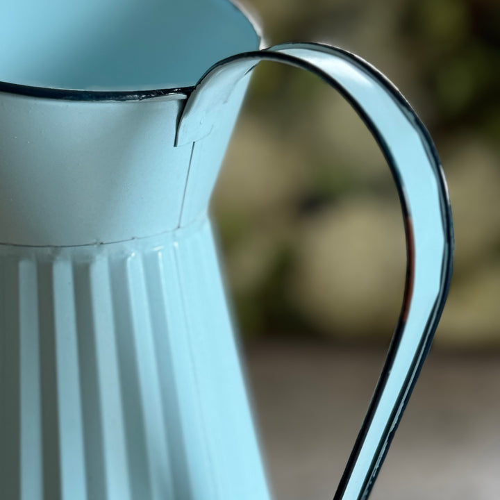 Close-up of a pale blue pitcher with a blurred background