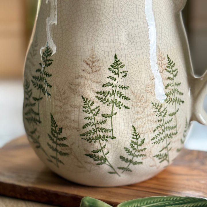 Clos up of Ceramic jug with fern design on a wooden surface