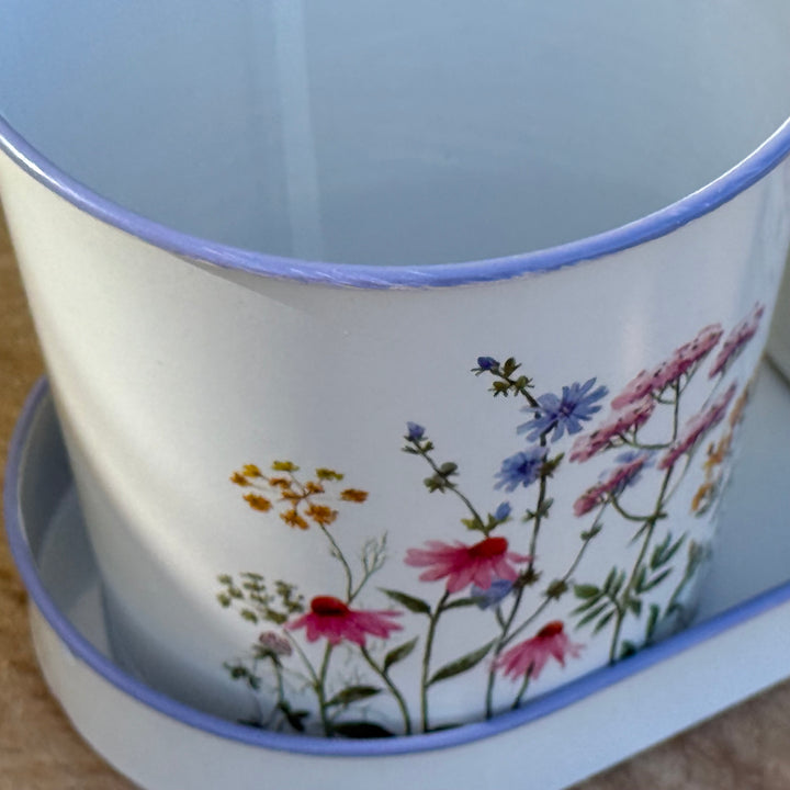 Ceramic pot with floral design on a wooden surface