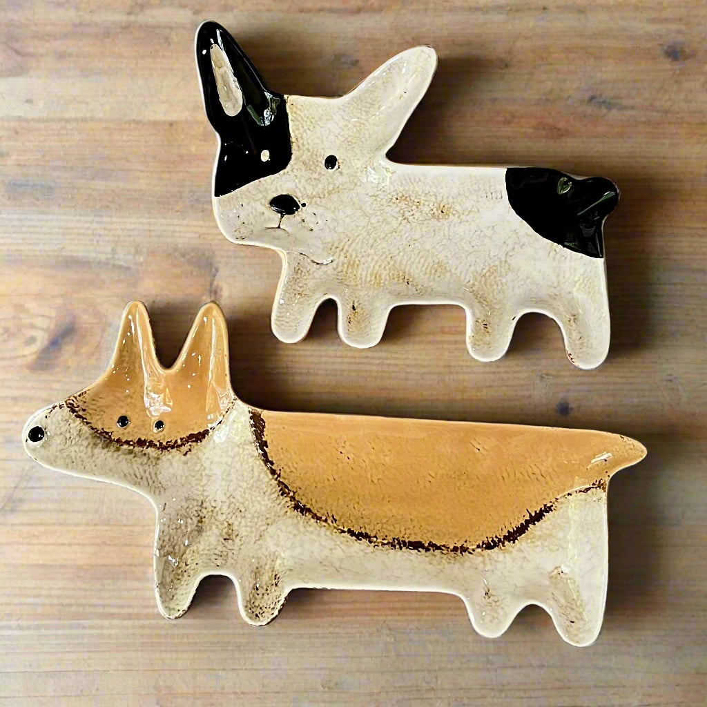 Two ceramic dog figurines on a wooden surface