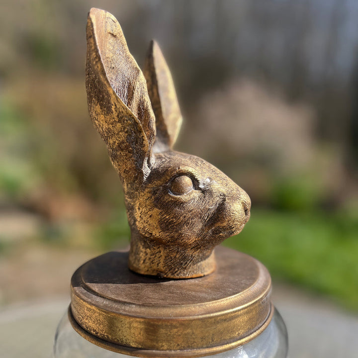 Large glass jar with a golden hare lid, showing the side of the hares head