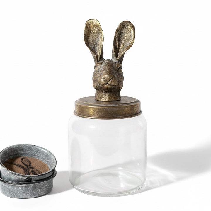 Large clear glass storage jar with a whimsical distressed golden hare lid topper