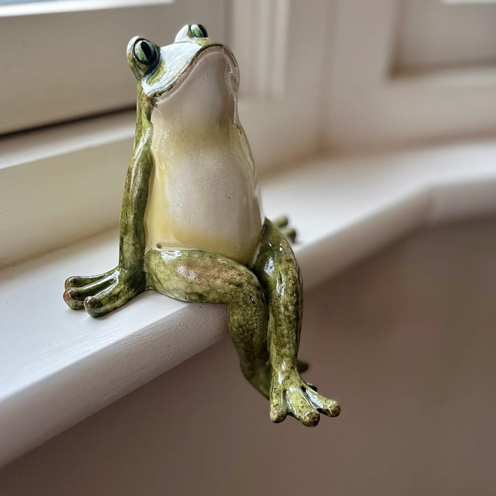 Green polyresin frog shelf sitter with crossed legs, hand-finished with a vintage ceramic-look glaze.