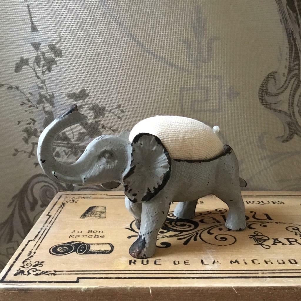Shabby chic French grey metal elephant pin cushion with a hessian padded back and two pins.