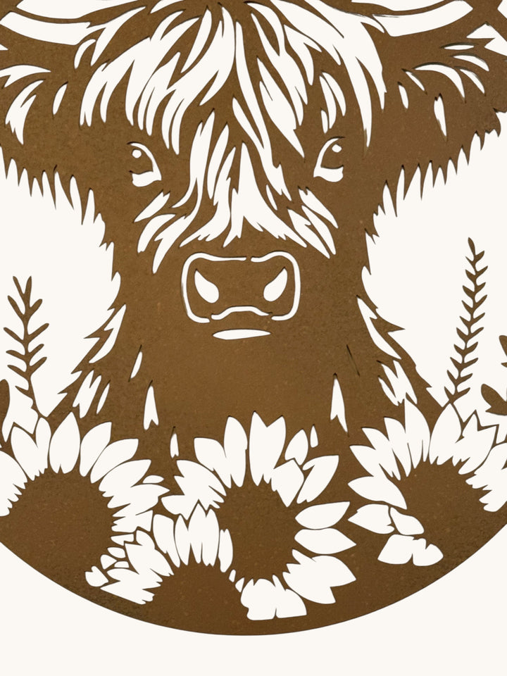 large rusty metal wall plaque featuring a detailed Highland cow surrounded by sunflowers and foliage.