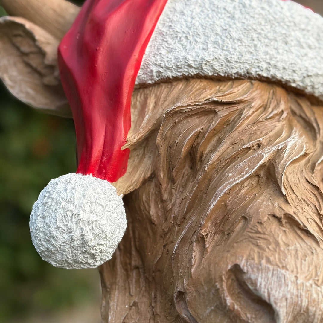 Vintage Hare resin Highland cow wall hanger wearing a red and white textured Santa hat for Christmas decor