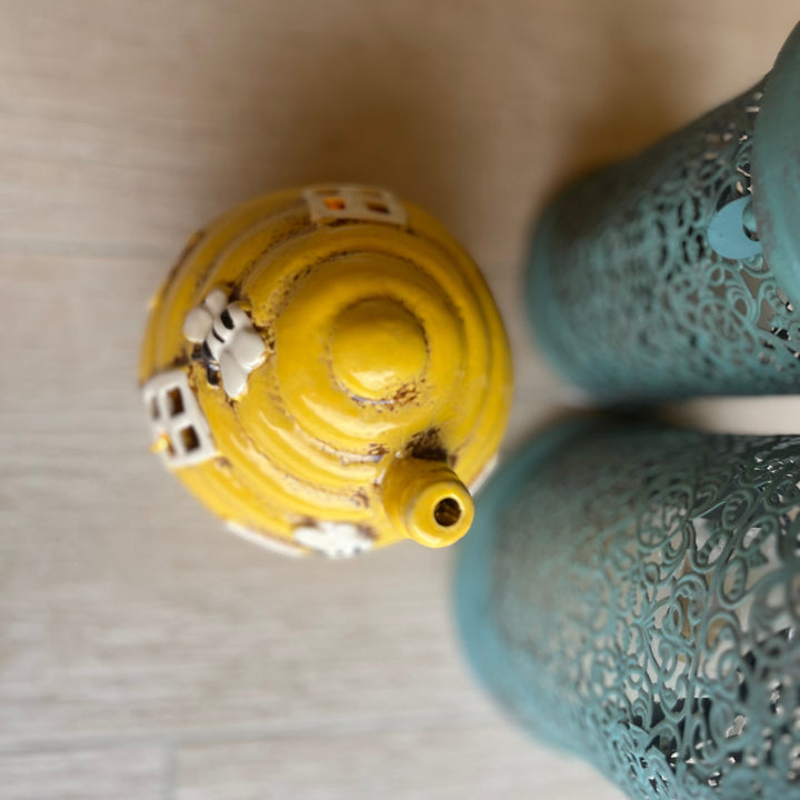 Close-up of a yellow and blue decorative lanterns on a neutral background