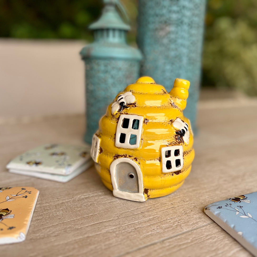 Yellow ceramic house-shaped object on a wooden surface with a blurred background